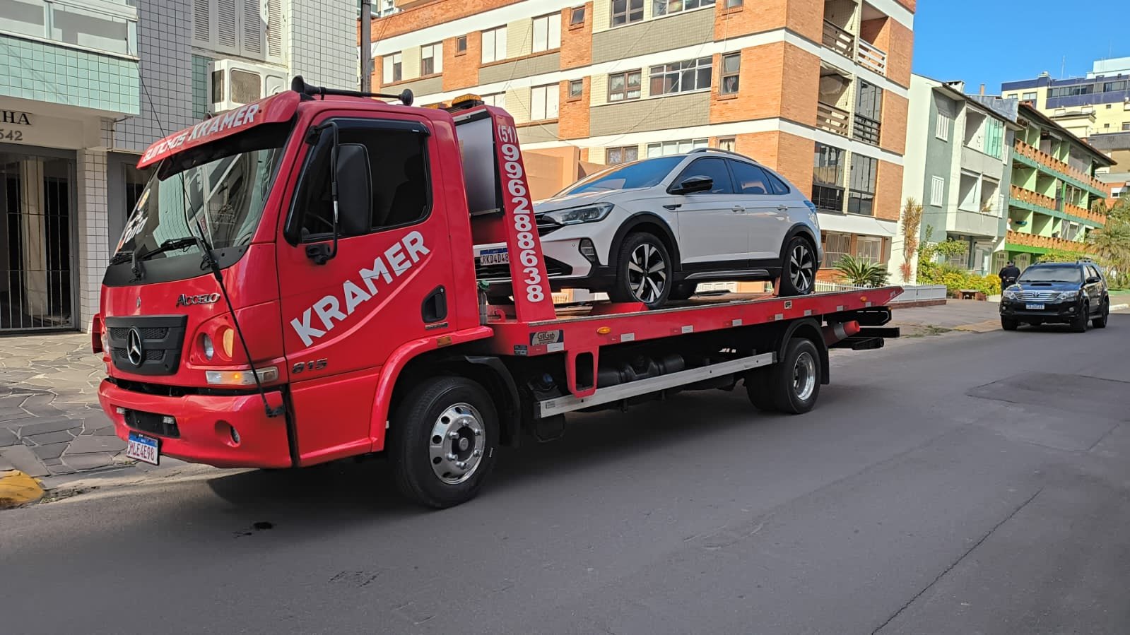 Caminhão guincho Guinchos Kramer transportando veículo no litoral